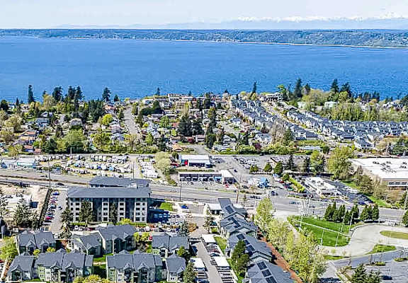 A bird's eye view of a town with a large body of water in the background.
