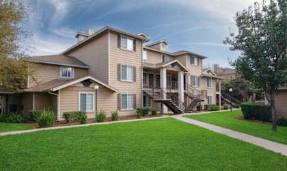 A row of houses with green lawns in front.