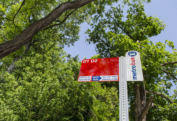 A Metrobus stop sign is displayed on a pole with a red sign below it. at Park Crest Apartments, Washington