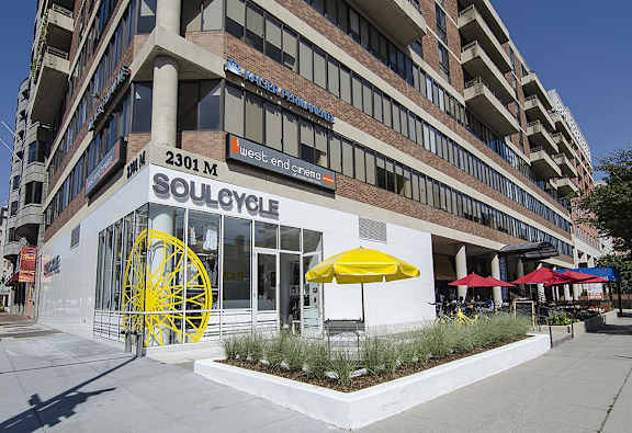 A building with a large yellow wheel in front of it.