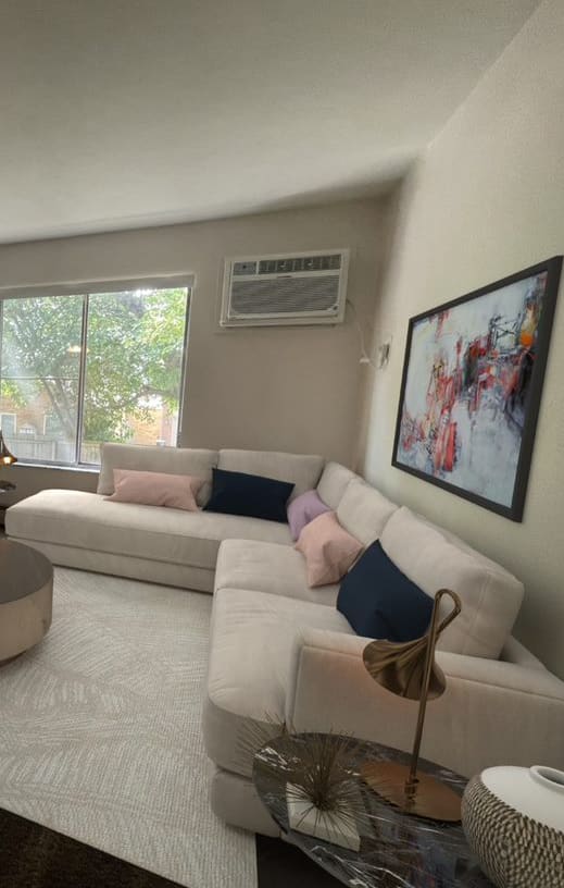 a living room with white couches and a large window