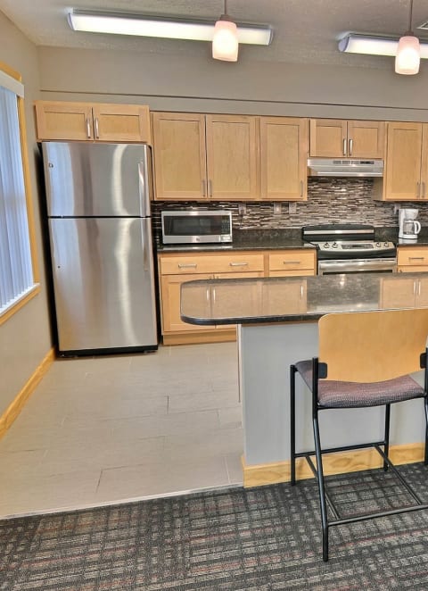 a kitchen with a counter and chairs