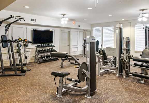 a gym with exercise equipment and a television