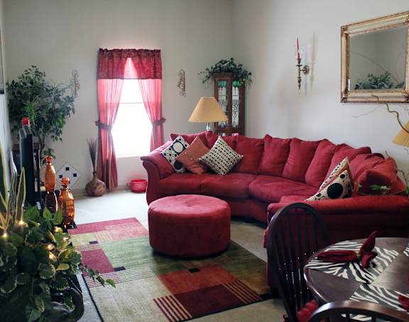 a living room with a red couch and a christmas tree