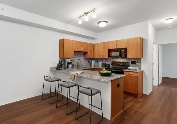 A kitchen with brown cabinets and a granite countertop.