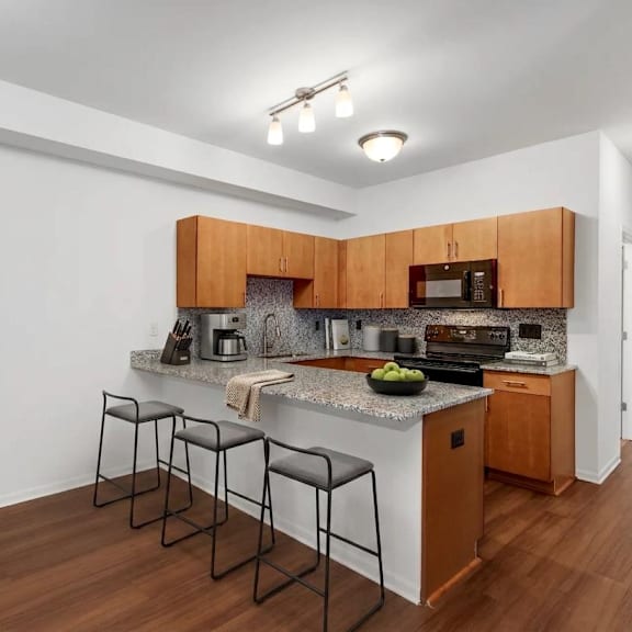 A kitchen with brown cabinets and a granite countertop.
