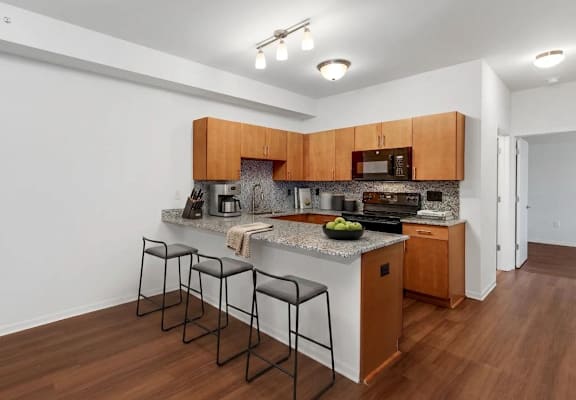 A kitchen with brown cabinets and a granite countertop.