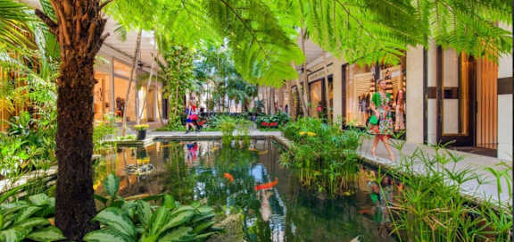 A serene garden with a pond and people enjoying the view.