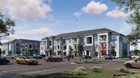 A modern apartment complex with cars parked in front.