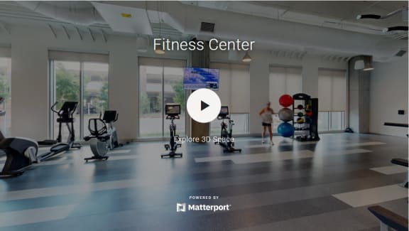 a fitness center with people exercising in it and the fitness center logo on the floor