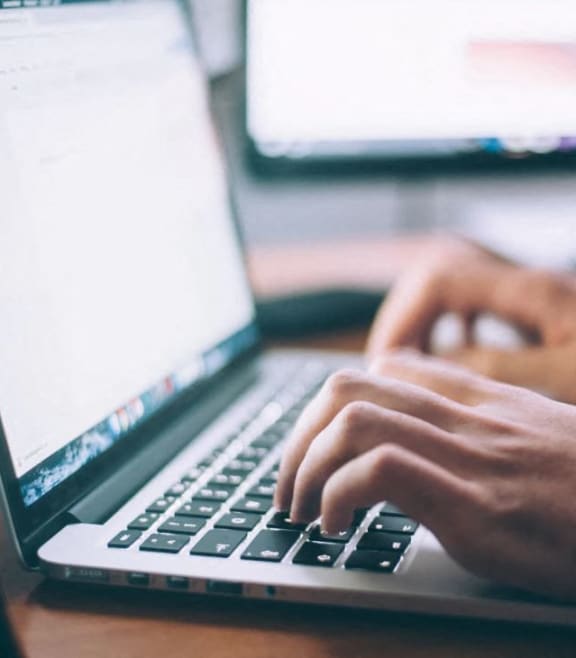 a person typing on a laptop computer