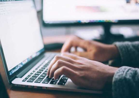 a person typing on a laptop computer