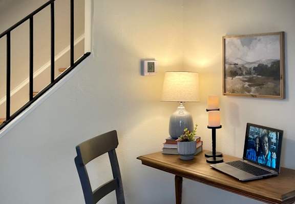 a desk with a laptop and a lamp on top of it