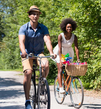 A man and a woman are riding bicycles on a road.