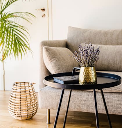 a living room with a couch and a table with a vase on it