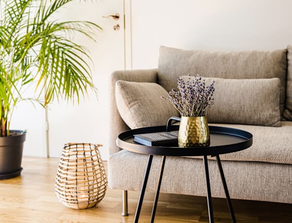 a living room with a couch and a table with a vase on it