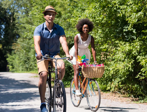 a man and a woman riding bikes on a road