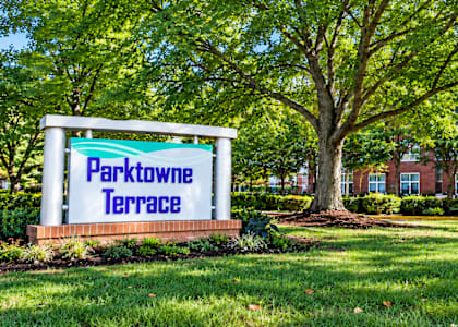 A sign that says Parktowne Terrace stands in front of a building.