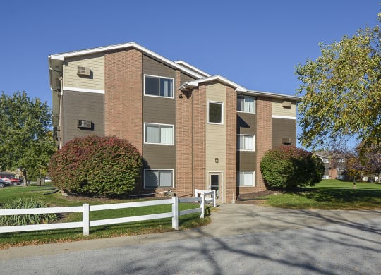 White Fence Leading to an Entrance Door for an Apartment Building at Timberland at Crestburck