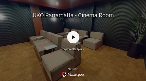 A 3D model of a cinema room with a play button overlay.