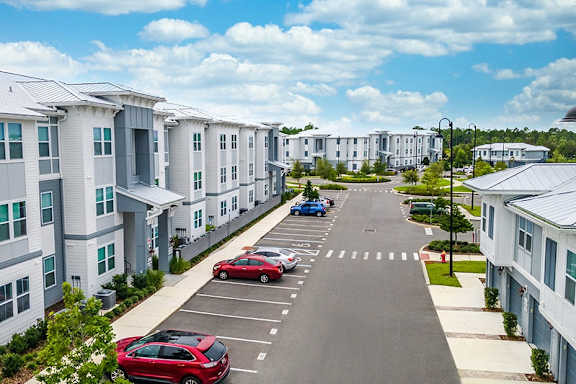an empty parking lot in front of an apartment building