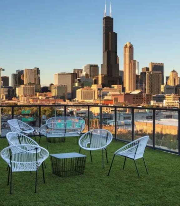 a view of the city skyline from a balcony with chairs and tables