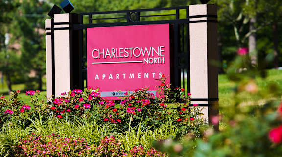 A sign for Charlestowne North Apartments is surrounded by flowers. at Charlestowne North Apartments, Maryland
