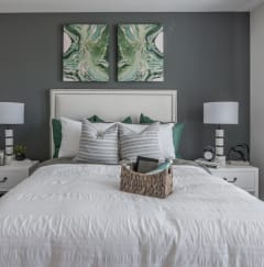 a bedroom with a white bed and two paintings on the wall