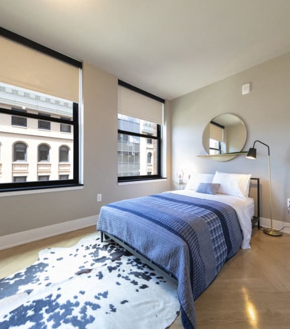 a bedroom with a bed and two windows