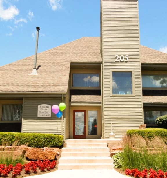 the front of a house with balloons outside