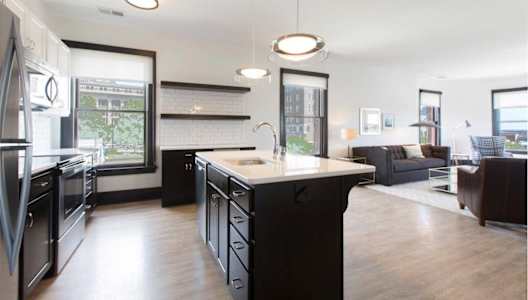 A modern kitchen with black appliances and a large island.