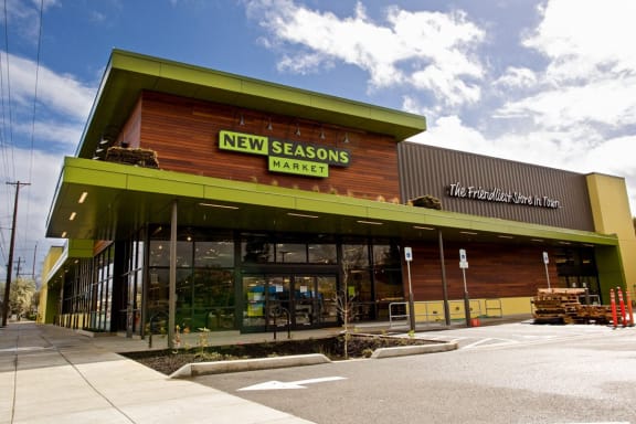 the front of a new seasons market building with a green roof