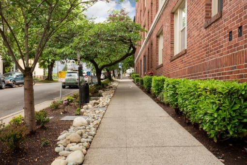 Street View of Property with Manicured Bushed and Rock Lined Tree Area  at Stockbridge Apartment Homes, Washington, 98101