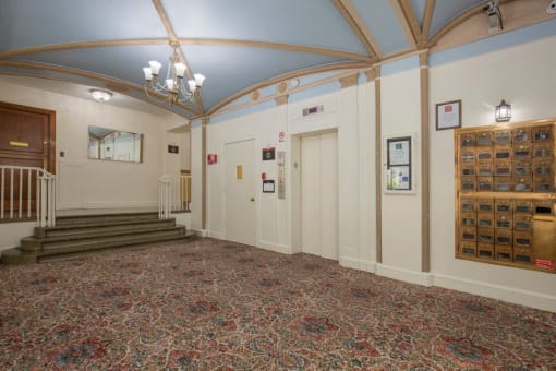 Lobby Image with Patterned Carpet, Blue Ceiling with Gold Cross Beaming and Chandelier at Stockbridge Apartment Homes, Washington, 98101