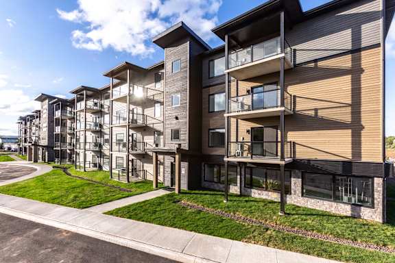 A modern apartment complex with a parking lot in front.