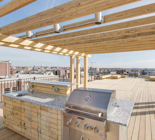 a roof deck with a barbecue and a view of the city at 1841 Columbia Road Apartments, Washington, Washington DC