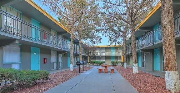 A courtyard with a bench surrounded by apartment buildings.