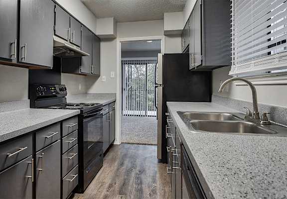 a kitchen with granite counter tops and stainless steel appliances at The Broadwater at Salado Creek, San Antonio, Texas