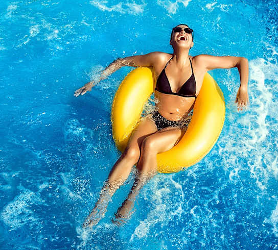 a woman in a swimming pool with a yellow raft