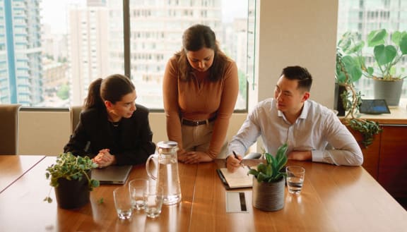 a group of people sitting at a table in a meeting