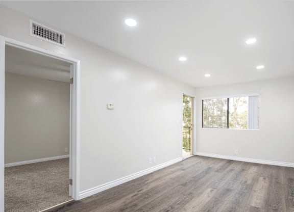 an empty living room with white walls and wood flooring at Huntington Terrace North Senior, Huntington Beach, CA