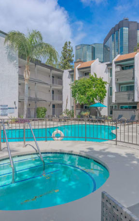 a swimming pool at a hotel with palm trees at City View Apartments at Warner Center, Woodland Hills