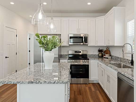 Kitchen with white cabinets, countertop, and modern appliances.