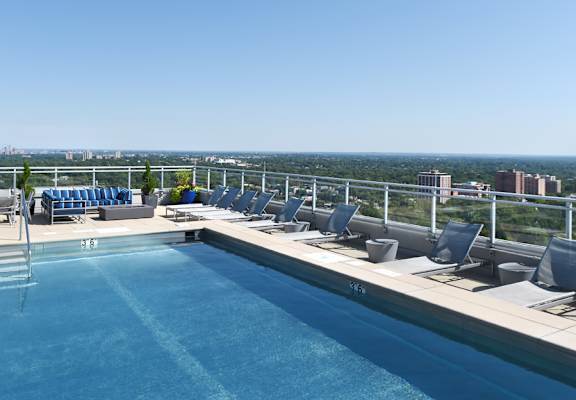 a swimming pool on the roof of a building with a city in the background  at Two Twelve Clayton, Clayton, MO, 63105
