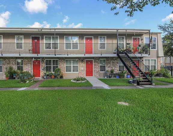an exterior view of a building with red doors and balconies
