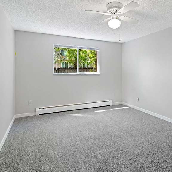 A room with a ceiling fan and a window.