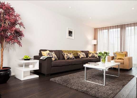 a living room with a brown couch and a white table