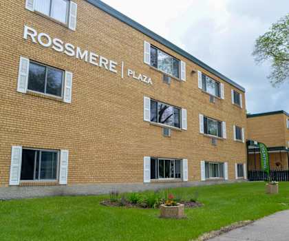 A brick building with the words Rossmere Plaza on the side.