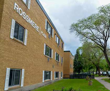 A brick building with the words Rossmere Plaza on the side.