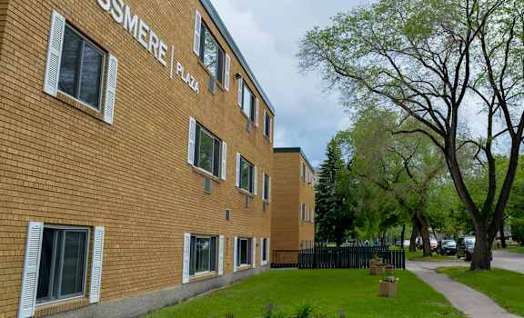 A brick building with the words Rossmere Plaza on the side.